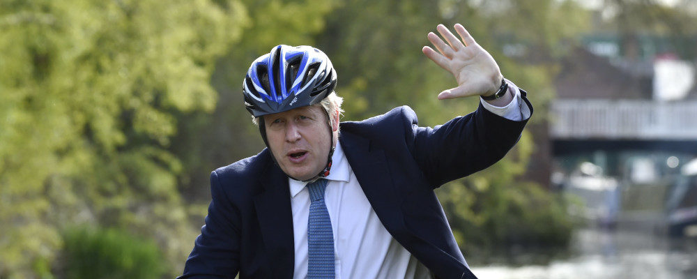 British Prime Minister Boris Johnson waves as he rides a bike ride along the towpath of the Stourbridge canal in the West Midlands during a Conservative party local election visit on May 5, 2021. Rui Vieira/AP Photo