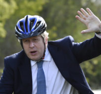 British Prime Minister Boris Johnson waves as he rides a bike ride along the towpath of the Stourbridge canal in the West Midlands during a Conservative party local election visit on May 5, 2021. Rui Vieira/AP Photo