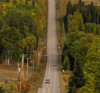 Motorists travel on a rural road framed by trees beginning to change colour, near Smithers, B.C. Darryl Dyck/The Canadian Press.