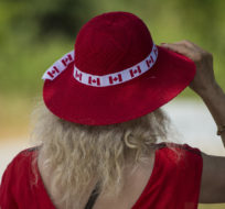 A woman adjusts her hat while celebrating Canada Day along the lake shore in Toronto on July 1, 2020. Tijana Martin/The Canadian Press.