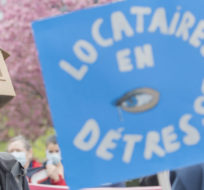 A man wears a cardboard house on his head during a demonstration calling for more affordable and social housing in Montreal on May 8, 2021. Graham Hughes/The Canadian Press.