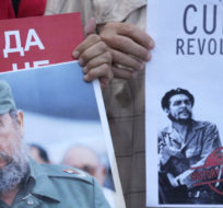 People hold pictures of the late Cuban leader Fidel Castro, during a protest against Cuba's anti-government protesters in front of the Cuban Embassy, in Belgrade, Serbia on July 20, 2021.Darko Vojinovic/AP Photo.