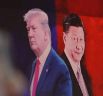 A computer screen shows images of Chinese President Xi Jinping, right, and U.S. President Donald Trump as a currency trader works at the foreign exchange dealing room of the KEB Hana Bank headquarters in Seoul, South Korea, Monday, Aug. 26, 2019. Ahn Young-joon/AP photo.