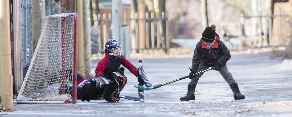 Children play hockey in an alleyway on a mild winter day in Montreal. Graham Hughes/The Canadian Press.