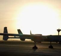 Technicians from MacDonald, Detwiller & Associates make final adjustments to a Heron unmanned surveillance drone on the tarmac at Kandahar Airfield just before a test flight under the setting sun on March 6, 2009 at Kandahar Airfield, Afghanistan. Murray Brewster/The Canadian Press.
