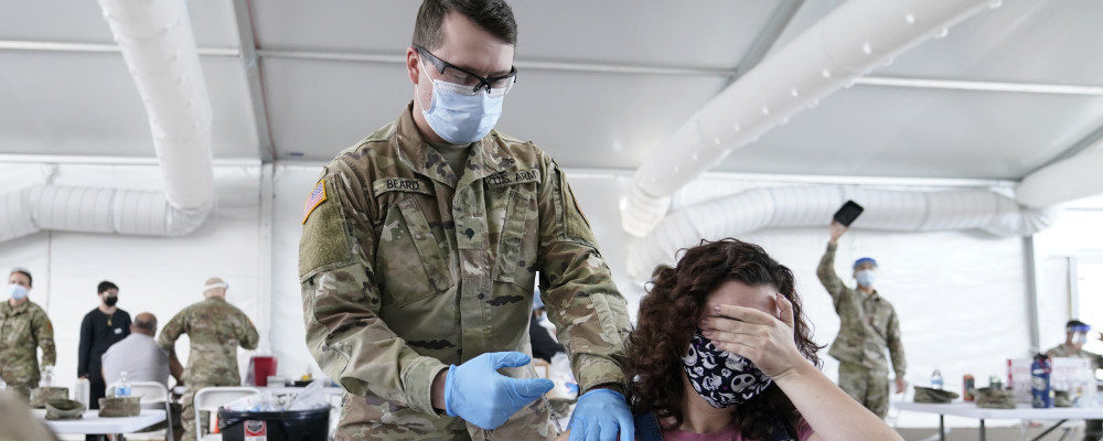 Leanne Montenegro, 21, covers her eyes as she doesn't like the sight of needles, while she receives the Pfizer COVID-19 vaccine at a FEMA vaccination center at Miami Dade College on April 5, 2021, in Miami. Lynne Sladky/AP Photo.