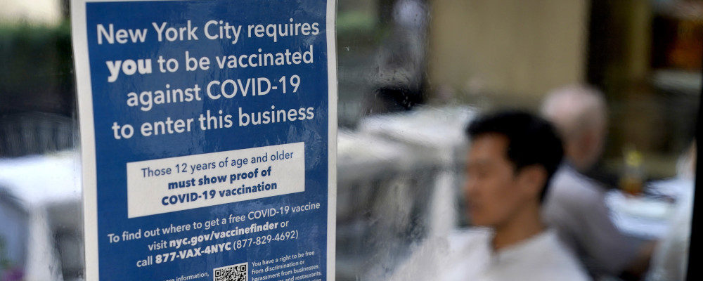 In this Sept. 13, 2021, file photo, a notice explaining that proof of vaccination is required to dine inside is seen at a restaurant in midtown Manhattan in New York. Seth Wenig/AP Photo.