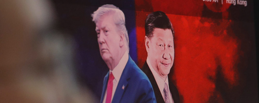 A computer screen shows images of Chinese President Xi Jinping, right, and U.S. President Donald Trump as a currency trader works at the foreign exchange dealing room of the KEB Hana Bank headquarters in Seoul, South Korea, Monday, Aug. 26, 2019. Ahn Young-joon/AP Photo.