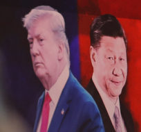 A computer screen shows images of Chinese President Xi Jinping, right, and U.S. President Donald Trump as a currency trader works at the foreign exchange dealing room of the KEB Hana Bank headquarters in Seoul, South Korea, Monday, Aug. 26, 2019. Ahn Young-joon/AP Photo.