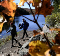 People take in the fall colours at Meech Lake in Chelsea, Que., on Sunday, Oct. 11, 2020. Justin Tang/The Canadian Press.