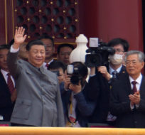 Chinese President Xi Jinping, center, waves next to former President Hu Jintao, right, during a ceremony to mark the 100th anniversary of the founding of the ruling Chinese Communist Party at Tiananmen Gate in Beijing Thursday, July 1, 2021. Ng Han Guan/AP Photo.