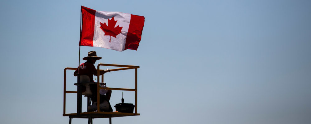 A lifeguard is silhouetted while sitting on a watchtower as a Canadian flag flies in the wind at Crescent Beach, in Surrey, B.C., Tuesday, July 6, 2021. Darryl Dyck/THE CANADIAN PRESS.