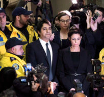 Jian Ghomeshi makes his way through a mob of media with his lawyer Marie Henein at a Toronto court on November 26, 2014. Darren Calabrese/THE CANADIAN PRESS.