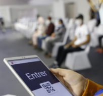A health worker checks the QR code of an arriving person before allowing them access to the area for different vaccines at the smart vaccinodrome in the suburbs of Casablanca, Morocco, on Thursday, Oct. 28, 2021. Abdeljalil Bounhar/AP Photo.