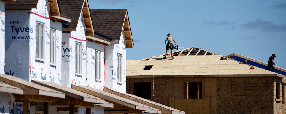 Builders work on the roof of a home in a new subdivision in the Ottawa suburb of Kanata, on Friday, July 30, 2021. Justin Tang/The Canadian Press. 