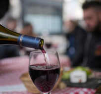 A customer pours a glass of Beaujolais Nouveau wine in a restaurant of Boulogne Billancourt, outside Paris, Thursday, Nov. 18, 2021. Christophe Ena/AP Photo.