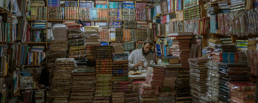 A bookshop owner repairs a book in Herat, Afghanistan, Monday, Nov. 22, 2021. Petros Giannakouris/AP Photo.