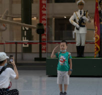 A child salutes for a photo near statues of Chinese military honor guards at the military museum in Beijing on Thursday, Sept. 3, 2020. Seventy-five years after Japan's surrender in World War II, and 30 years after its economic bubble popped, the emergence of a 21st century Asian power is shaking up the status quo. Ng Han Guan/AP Photo.