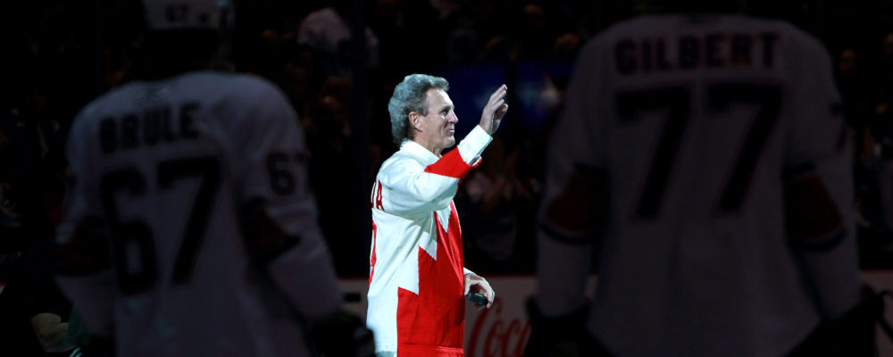 Canadian hockey legend Paul Henderson, who scored the game-winning goal in the 1972 Summit Series against the Soviet Union, centre, is framed by Edmonton Oilers' Gilbert Brule, left, and Tom Gilbert as he takes to the ice for a ceremonial faceoff before the Vancouver Canucks and Edmonton Oilers NHL hockey game in Vancouver, B.C., on Saturday April 2, 2011. Darryl Dyck/The Canadian Press. 