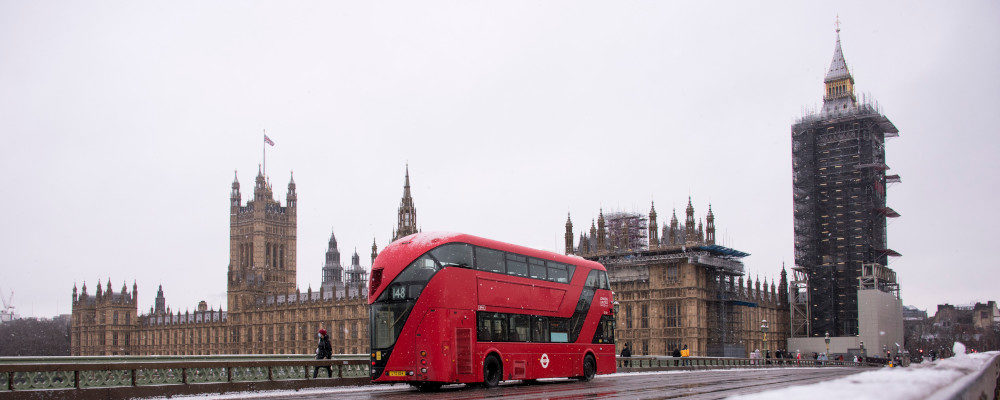 A double decker bus crosses Westminster Bridge against the backdrop of the Palace of Westminster, during a snow fall in London, Sunday, Jan. 24, 2021. Alberto Pezzali/AP Photo.