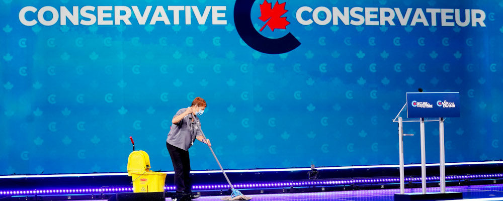 A woman cleans the stage at Conserative leader Erin O'Toole's election night headquaters during the Canadian federal election in Oshawa, Ont., on Monday, September 20, 2021. Adrian Wyld/The Canadian Press.