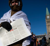 A person holds a copy of the Canadian Charter of Rights and Freedoms during a rally against COVID-19 restrictions on Parliament Hill, which began as a cross-country convoy protesting a federal vaccine mandate for truckers, in Ottawa, on Saturday, Jan. 29, 2022. Justin Tang/The Canadian Press. 