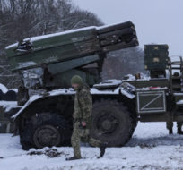 Ukrainian servicemen walk by a deactivated Russian military multiple rocket launcher on the outskirts of Kharkiv, Ukraine on Feb. 25, 2022. Vadim Ghirda/AP Photo.