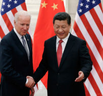 In this Dec. 4, 2013, file photo, Chinese President Xi Jinping, right, shakes hands with then U.S. Vice President Joe Biden as they pose for photos at the Great Hall of the People in Beijing. Lintao Zhang/AP Photo.