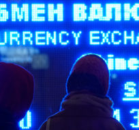 Women look at a screen displaying exchange rate at a currency exchange office in St. Petersburg, Russia, Tuesday, March 1, 2022. The Russian currency plunged about 30% against the U.S. dollar Monday after Western nations announced moves to block some Russian banks from the SWIFT international payment system and to restrict Russia's use of its massive foreign currency reserves. Dmitri Lovetsky/AP Photo.