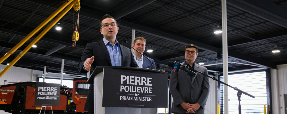 Pierre Poilievre speaks at a press conference, flanked by Sask. MPs Andrew Sheer and Corey Tochor, from left, at Brandt Tractor Ltd. in Regina on Friday, March 4, 2022. Michael Bell/The Canadian Press.
