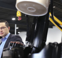 Pierre Poilievre glances at the camera briefly while getting a tour of machinery after a press conference at Brandt Tractor Ltd. in Regina on Friday, March 4, 2022. Michael Bell/The Canadian Press.