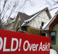 A for sale sign outside a home indicates that it has sold for over the asking price, in Ottawa, on Monday, March 1, 2021. Justin Tang/The Canadian Press.