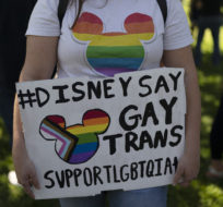 Disney employee Tiffany Cooper holds a sign to protest the company's stance on LGBTQ issues in Glendale, Calif., Tuesday, March 22, 2022. With some workers across the U.S. threatening a walkout, The Walt Disney Co. finds itself performing a high-wire act of balancing the expectations of a diverse workforce against demands from an increasingly polarized and politicized marketplace. Jae C. Hong/AP Photo.