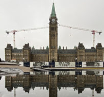 The centre block of Parliament Hill is reflected in water, Thursday, March 24, 2022 in Ottawa. Adrian Wyld/The Canadian Press.