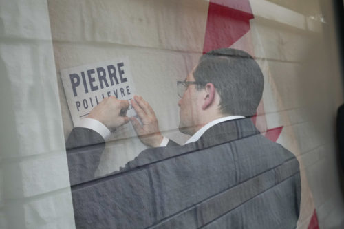 Federal Conservative leadership candidate Pierre Poilievre signs a placard at the University of British Columbia on April 7, 2022. Darryl Dyck/The Canadian Press.