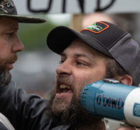 A man, right, who was attending a protest with people opposed to COVID-19 restrictions yells in the face of a counter-protester after he interrupted their event, in Vancouver, on Sunday, May 3, 2020. Darryl Dyck/The Canadian Press.