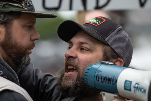 A man, right, who was attending a protest with people opposed to COVID-19 restrictions yells in the face of a counter-protester after he interrupted their event, in Vancouver, on Sunday, May 3, 2020. Darryl Dyck/The Canadian Press.