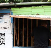 A worker at Hope House, an organization that sponsors the use of cryptocurrencies in El Zonte beach, makes a purchase at a small store that accepts Bitcoin, in Tamanique, El Salvador on June 9, 2021. Salvador Melendez/AP Photo.