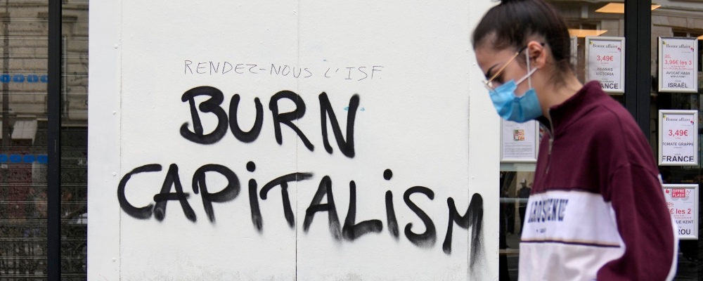 A painting reads "Give us back the solidarity tax on wealth, Burn Capitalism" as the environmental group Extinction Rebellion takes part of a three-day demonstration against what they call France's inaction on climate issues, during an occupation in the district of Porte de Saint Denis in the center of Paris, France, Monday, April 18, 2022. Francois Mori/AP Photo.