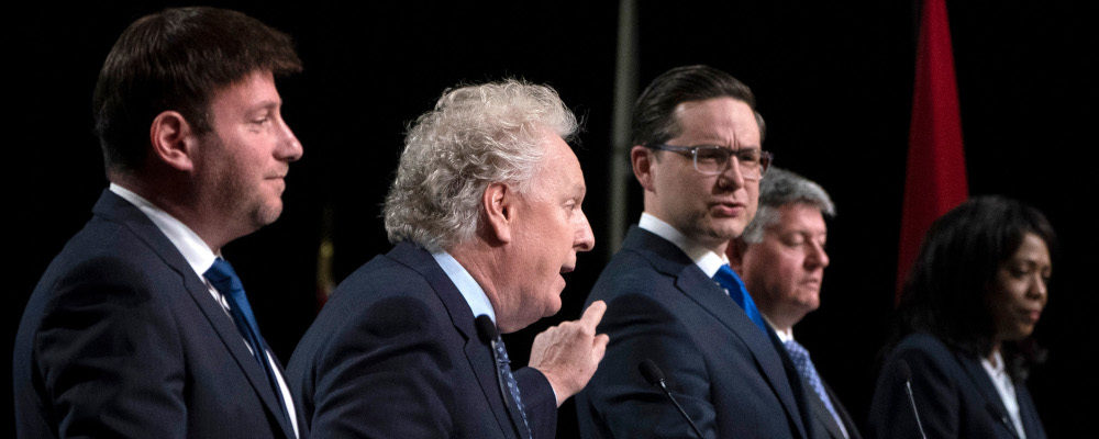Conservative leadership candidates Jean Charest and Pierre Poilievre spar as Roman Baber, Scott Aitchison
and Leslyn Lewis look on during a debate at the Canada Strong and Free Network conference, in Ottawa, Thursday, May 5, 2022. Adrian Wyld/The Canadian Press.