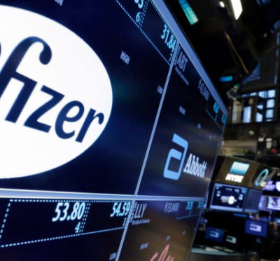 This April 6, 2016, file photo shows the Pfizer logo appearing on a screen above its trading post on the floor of the New York Stock Exchange. Richard Drew/AP Photo.