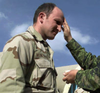 Canadian military chaplain Major Laurelle Callaghan of Edmonton  (right) makes the sign of the cross on the forehead of an American soldier during Ash Wednesday services at the airbase in Kandahar, Afghanistan Wednesday February 13, 2002. Kevin Frayer/CP Photo.