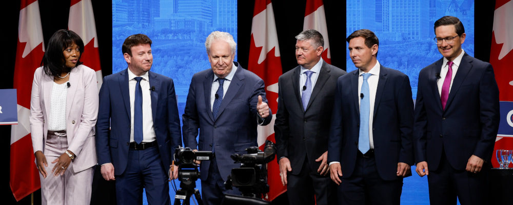 Candidates, left to right, Leslyn Lewis, Roman Baber, Jean Charest, Scott Aitchison, Patrick Brown, and Pierre Poilievre pose on stage following the Conservative Party of Canada English leadership debate in Edmonton, Alta., Wednesday, May 11, 2022. Jeff McIntosh/The Canadian Press.