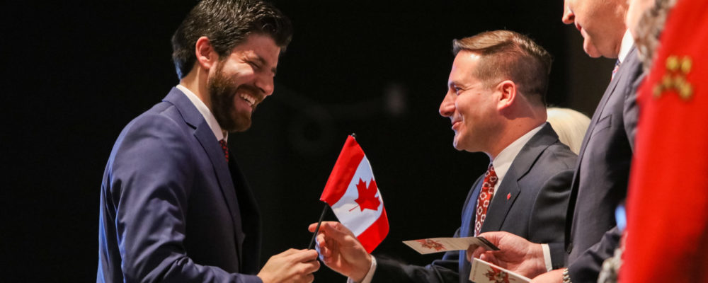 Tareq Hadhad receives a Canadian flag from Immigration Minister Marco Mendicino at the Oath of Citizenship ceremony at The Canadian Museum of Immigration at Pier 21 in Halifax on Jan. 15, 2020. Riley Smith/The Canadian Press.