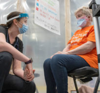 A doctor speaks with a patient during a demonstration at a mass vaccination clinic in Cobourg, Ontario on Monday, March 15, 2021. Frank Gunn/The Canadian Press.
