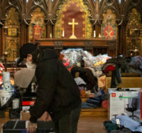 Zack Grant from Toronto's Holy Trinity Church sifts through donations for those in need, on Tuesday, January 11, 2022. Chris Young/The Canadian Press.