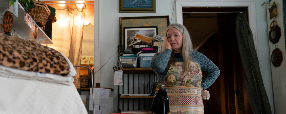 Nancy Rose, who contracted COVID-19 in 2021 and continues to exhibit long-haul symptoms including brain fog and memory difficulties, pauses while organizing her desk space, Tuesday, Jan. 25, 2022, in Port Jefferson, N.Y. Rose, 67, said many of her symptoms waned after she got vaccinated, though she still has bouts of fatigue and memory loss. John Minchillo/AP Photo.