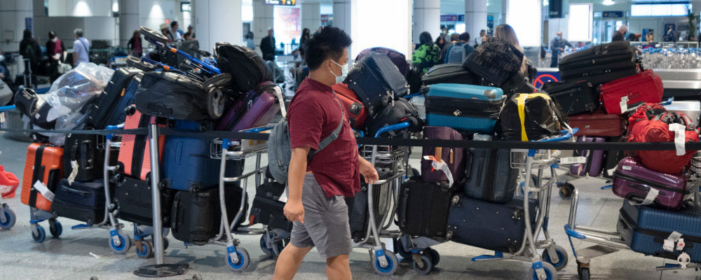 A passenger looks for his luggage among a pile of unclaimed baggage at Pierre Elliott Trudeau airport, in Montreal, Wednesday, June 29, 2022. Ryan Remiorz/The Canadian Press.