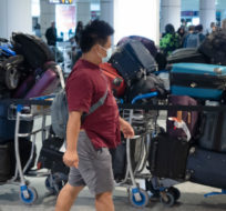 A passenger looks for his luggage among a pile of unclaimed baggage at Pierre Elliott Trudeau airport, in Montreal, Wednesday, June 29, 2022. Ryan Remiorz/The Canadian Press.