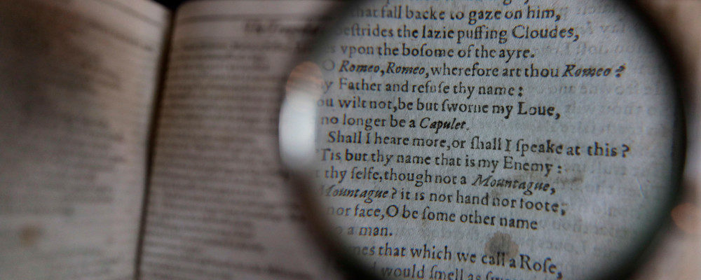 Looking through a magnifying glass to read lines from the play 'Romeo and Juliet' as William Shakespeare's First Folio is displayed at Christie's auction rooms in London, Monday, Jan. 13, 2020. The book was published in 1623 and contains 36 of Shakespeare's plays. The book which will go for auction in New York on April 24, is estimated at 4-6 million US dollars. Kirsty Wigglesworth/AP Photo.